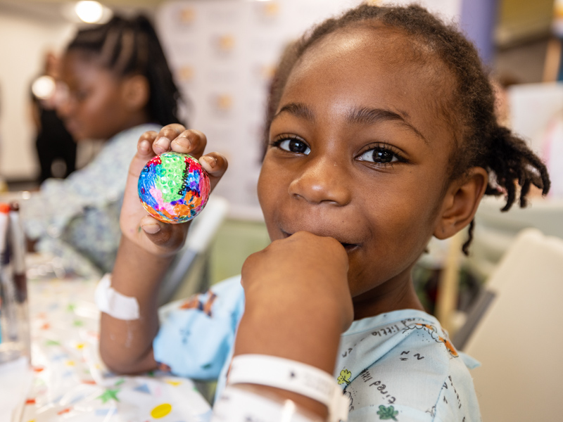 Children's of Mississippi patient Zaniyah Rice of Indianola shows the golf ball she designed. Jay Ferchaud/ UMMC Photography